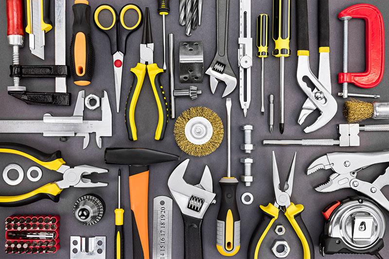 set of hand various work tools on grey background top view set of hand various work tools on grey background top view including different kinds of wrenches, pliers, clamps, calipers and other
